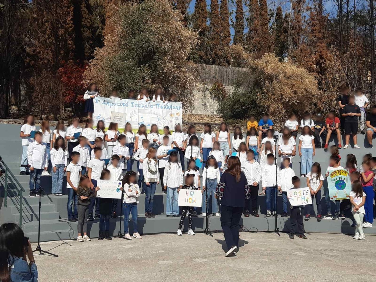 «Η γη πονά»: το τραγούδι που τραγούδησε το 1o Δημοτικό Σχολείο Παλλήνης στο Οινοποιείο Πέτρου. Στο φόντο το αποτύπωμα της πρόσφατης πυρκαγιάς που έπληξε το Δήμο Παλλήνης.